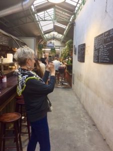 Me holding my iPhone taking a picture of a menu in the Le Marais Market
